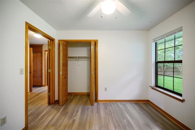 1001 Norris Ave, Broken Bow, OK 74728 - unfurnished bedroom featuring wood finished floors, a closet, a textured ceiling, and ceiling fan