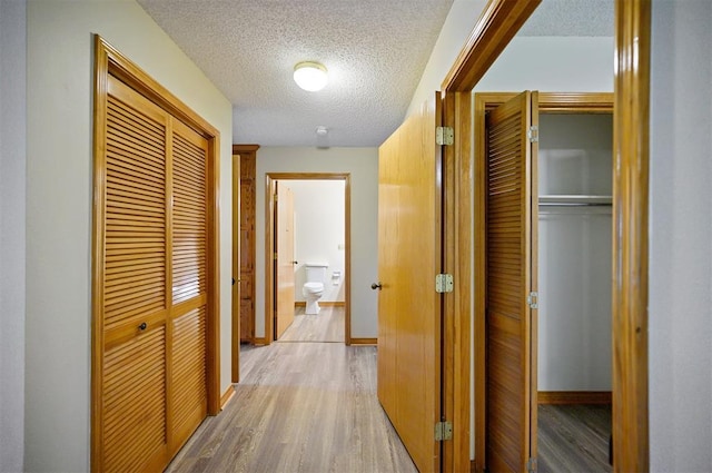 1001 Norris Ave, Broken Bow, OK 74728 - hallway with light wood-style flooring and a textured ceiling