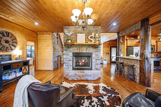 25 Paint Horse Cir, Broken Bow, OK 74728 - living room with wooden ceiling, wood walls, a stone fireplace, a chandelier, and wood finished floors