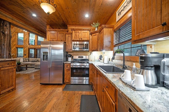 25 Paint Horse Cir, Broken Bow, OK 74728 - kitchen featuring stainless steel appliances, wood ceiling, brown cabinetry, dark wood-style flooring, and light stone counters