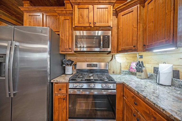 25 Paint Horse Cir, Broken Bow, OK 74728 - kitchen with appliances with stainless steel finishes, brown cabinetry, and light stone countertops