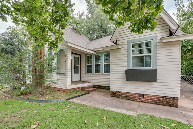 2524 NW 15th St, Oklahoma City, OK 73107 - view of front of home with a shingled roof, a front yard, and a patio area