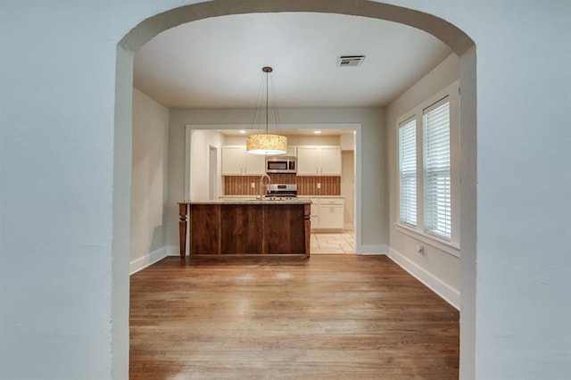 2524 NW 15th St, Oklahoma City, OK 73107 - kitchen with stainless steel appliances, light wood-type flooring, and arched walkways