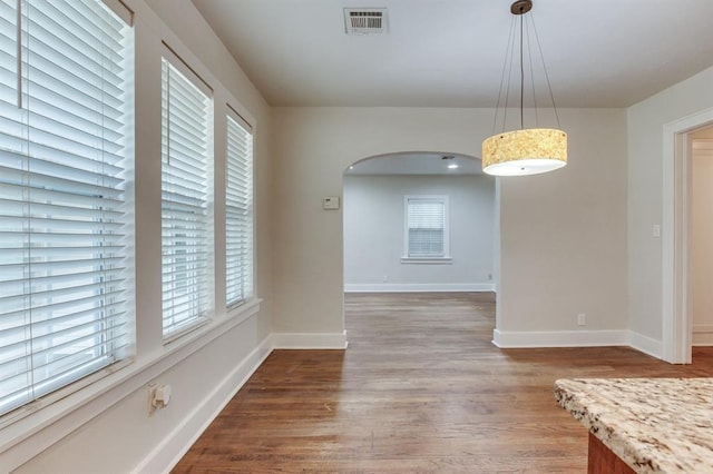 2524 NW 15th St, Oklahoma City, OK 73107 - unfurnished dining area featuring arched walkways and wood finished floors