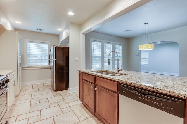 2524 NW 15th St, Oklahoma City, OK 73107 - kitchen with appliances with stainless steel finishes, light stone counters, hanging light fixtures, stone tile flooring, and brown cabinetry