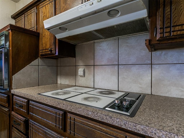 14601 Prairie Ln, Oklahoma City, OK 73165 - kitchen featuring extractor fan, tasteful backsplash, white stovetop, and dark countertops
