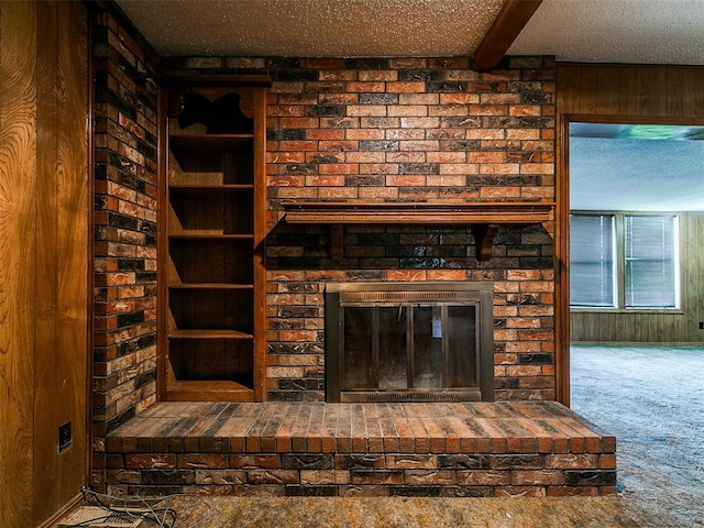 14601 Prairie Ln, Oklahoma City, OK 73165 - detailed view of a fireplace, carpet flooring, wood walls, beam ceiling, and a textured ceiling