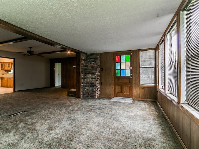14601 Prairie Ln, Oklahoma City, OK 73165 - unfurnished living room featuring wood walls, a textured ceiling, carpet flooring, and ceiling fan