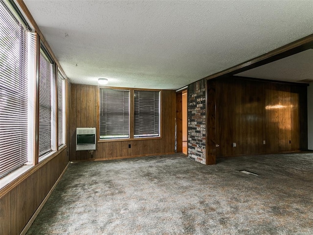 14601 Prairie Ln, Oklahoma City, OK 73165 - unfurnished living room with heating unit, wooden walls, a textured ceiling, and carpet