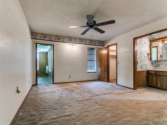 14601 Prairie Ln, Oklahoma City, OK 73165 - unfurnished bedroom with a textured wall, light carpet, multiple windows, a textured ceiling, and ensuite bathroom