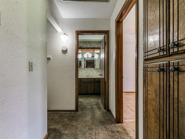 14601 Prairie Ln, Oklahoma City, OK 73165 - hallway featuring a textured wall and dark carpet