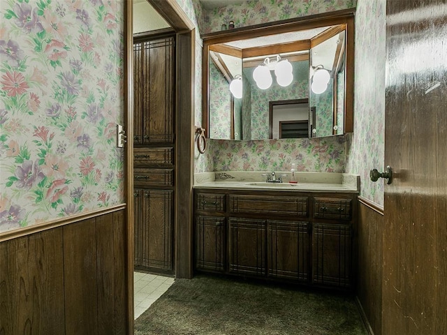 14601 Prairie Ln, Oklahoma City, OK 73165 - bathroom with wallpapered walls, vanity, and wainscoting