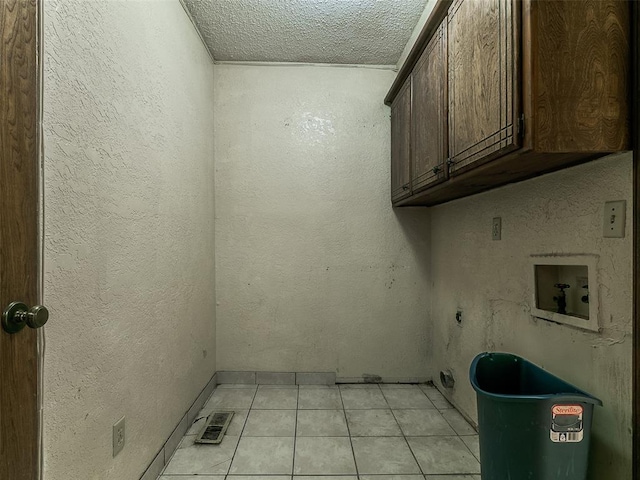 14601 Prairie Ln, Oklahoma City, OK 73165 - laundry area featuring cabinet space, washer hookup, light tile patterned flooring, a textured ceiling, and electric dryer hookup