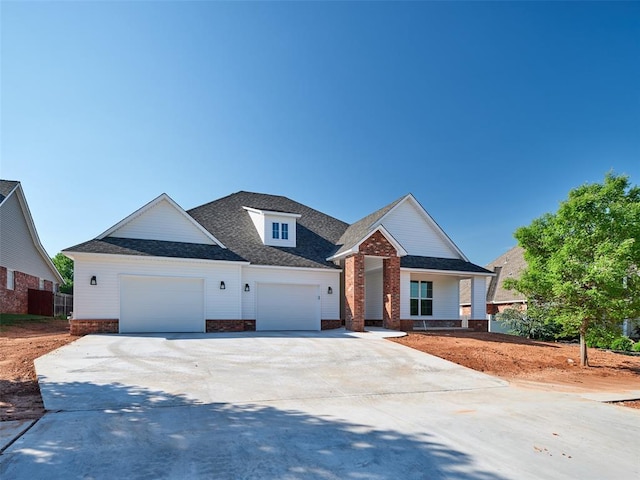 408 Nantucket Blvd, Norman, OK 73071 - view of front facade with brick siding, concrete driveway, an attached garage, and a shingled roof