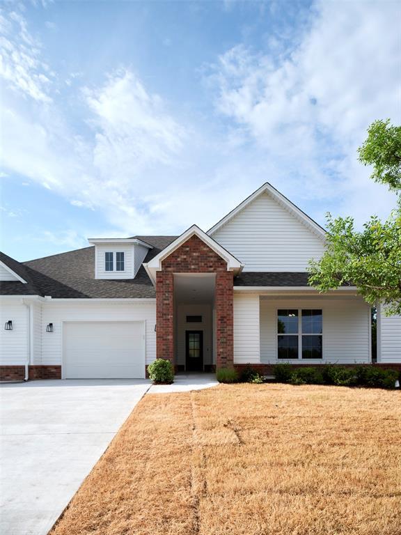 408 Nantucket Blvd, Norman, OK 73071 - view of front of house featuring an attached garage, driveway, roof with shingles, brick siding, and a front yard