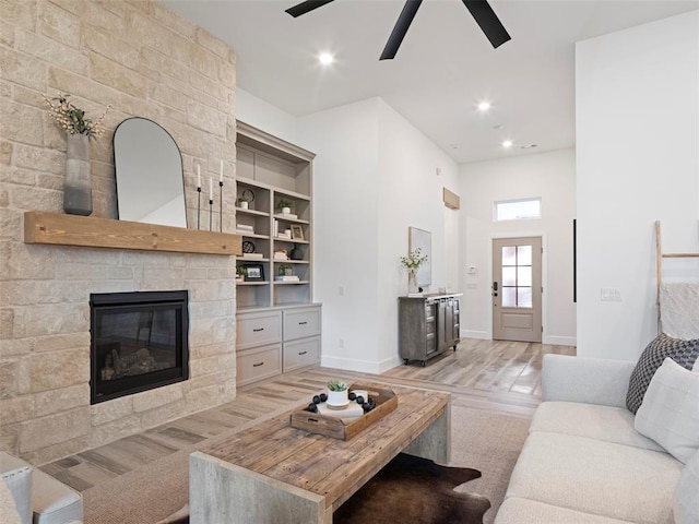 408 Nantucket Blvd, Norman, OK 73071 - living room with light wood-type flooring, a ceiling fan, a stone fireplace, and recessed lighting