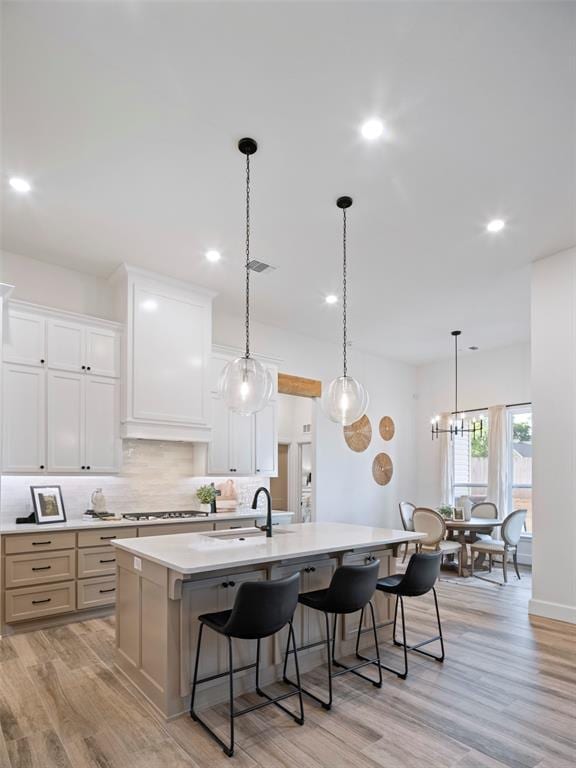 408 Nantucket Blvd, Norman, OK 73071 - kitchen with decorative backsplash, a center island with sink, light wood-style floors, a breakfast bar, and recessed lighting