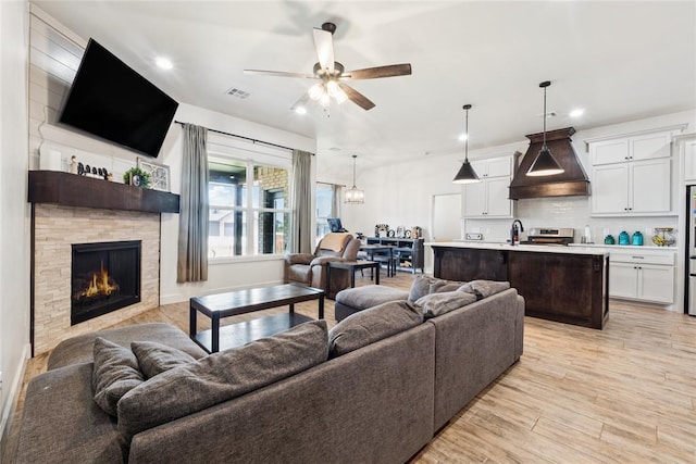 10413 SW 51st St, Mustang, OK 73064 - living room with ceiling fan, recessed lighting, a fireplace, and light wood-style floors