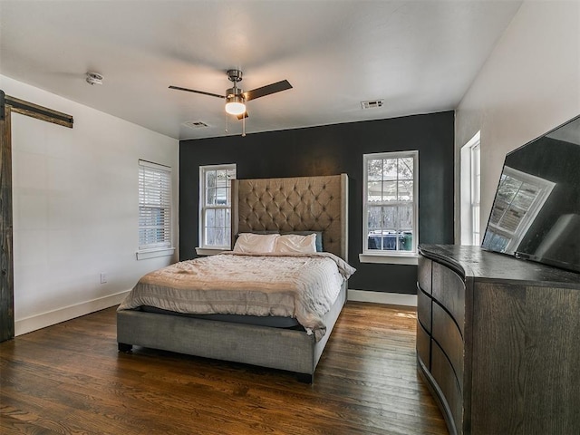 2016 Hardin Dr, Oklahoma City, OK 73111 - bedroom featuring multiple windows, wood finished floors, a barn door, and ceiling fan