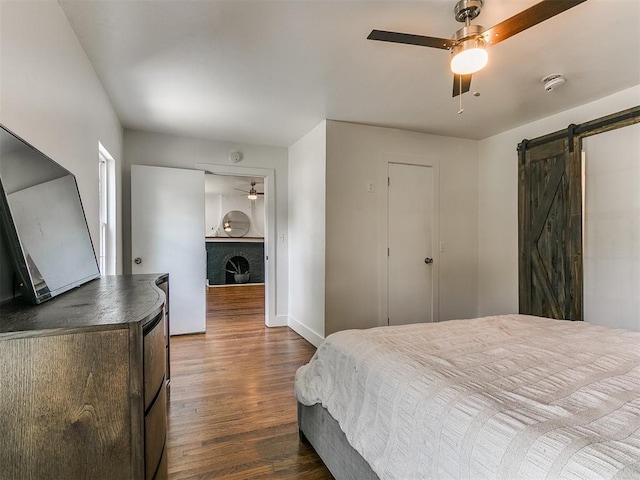 2016 Hardin Dr, Oklahoma City, OK 73111 - bedroom featuring dark wood-style floors, a barn door, and a ceiling fan