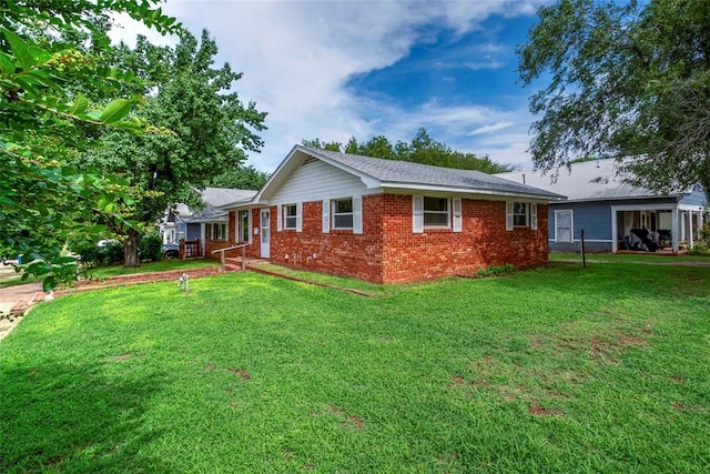 420 E 12th St, Chandler, OK 74834 - view of side of property with brick siding and a yard