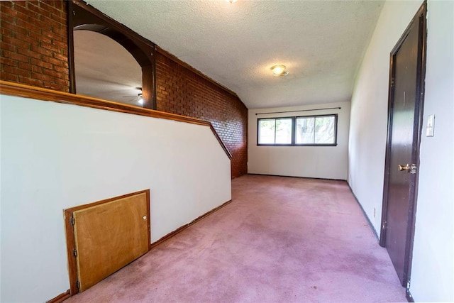 420 E 12th St, Chandler, OK 74834 - spare room with light carpet, brick wall, a textured ceiling, and a ceiling fan
