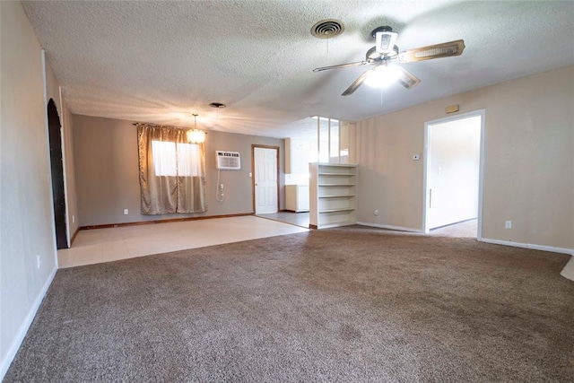 420 E 12th St, Chandler, OK 74834 - unfurnished living room featuring ceiling fan, carpet, a textured ceiling, and a wall mounted AC
