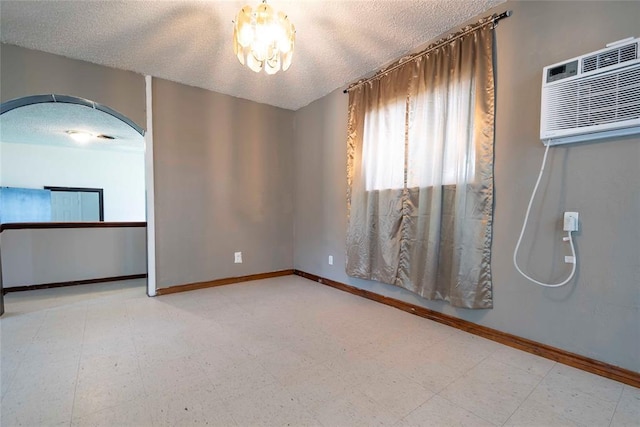 420 E 12th St, Chandler, OK 74834 - unfurnished room featuring arched walkways, a textured ceiling, tile patterned floors, and an AC wall unit
