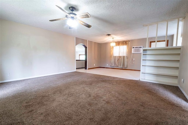 420 E 12th St, Chandler, OK 74834 - carpeted empty room featuring arched walkways, ceiling fan, a textured ceiling, an AC wall unit, and a chandelier