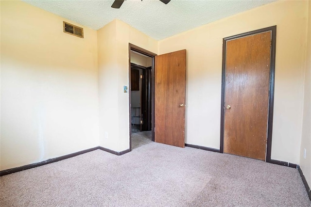 420 E 12th St, Chandler, OK 74834 - unfurnished bedroom featuring carpet floors, a ceiling fan, and a textured ceiling
