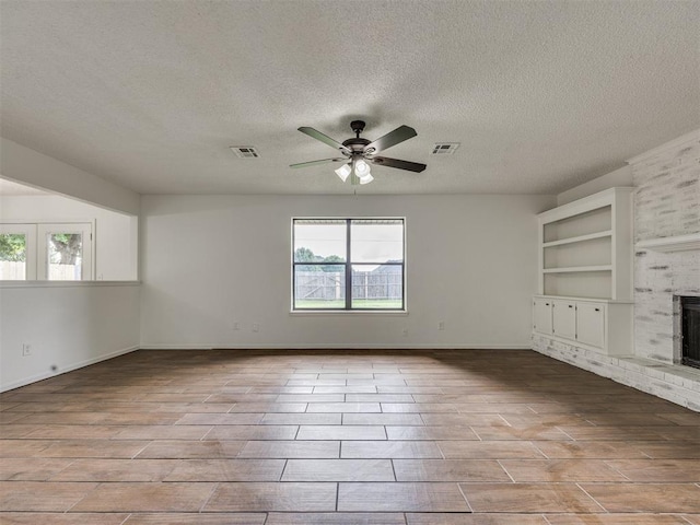 8317 Curtis Ter, Oklahoma City, OK 73132 - unfurnished living room featuring a fireplace, a textured ceiling, ceiling fan, and wood finished floors