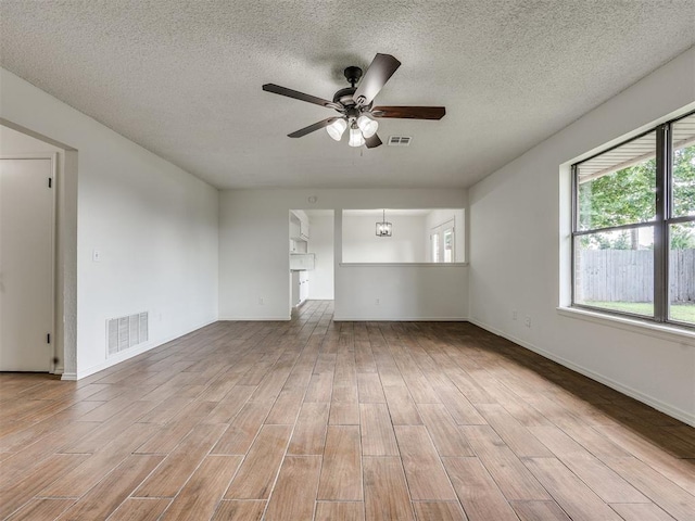 8317 Curtis Ter, Oklahoma City, OK 73132 - spare room featuring wood finished floors, a ceiling fan, healthy amount of natural light, and a textured ceiling