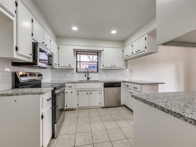 8317 Curtis Ter, Oklahoma City, OK 73132 - kitchen featuring appliances with stainless steel finishes, tasteful backsplash, white cabinetry, light tile patterned floors, and recessed lighting