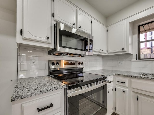 8317 Curtis Ter, Oklahoma City, OK 73132 - kitchen featuring stainless steel appliances, white cabinets, tasteful backsplash, and light stone counters