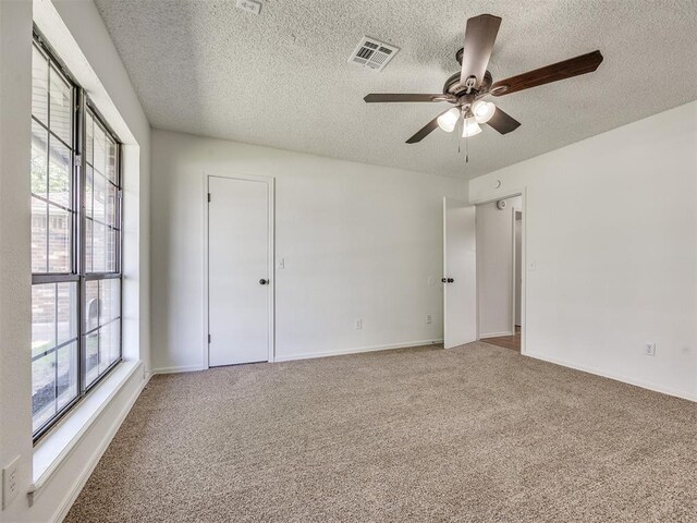 8317 Curtis Ter, Oklahoma City, OK 73132 - empty room featuring a textured ceiling, a ceiling fan, and carpet
