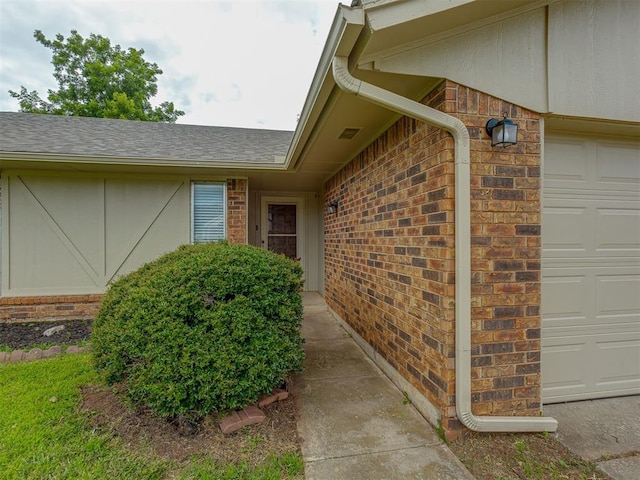 10428 Fairfax Ln, Yukon, OK 73099 - property entrance featuring brick siding, roof with shingles, and a garage