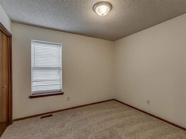10428 Fairfax Ln, Yukon, OK 73099 - spare room featuring carpet and a textured ceiling