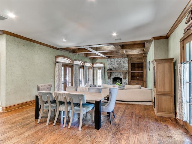 5708 Normandy Ter, Oklahoma City, OK 73142 - dining area featuring crown molding, wood finished floors, a stone fireplace, built in features, and recessed lighting