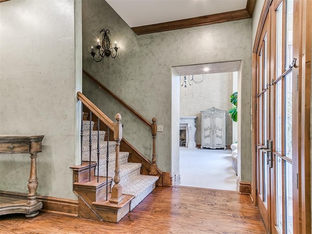 5708 Normandy Ter, Oklahoma City, OK 73142 - entryway featuring wood finished floors, a chandelier, stairway, crown molding, and a fireplace