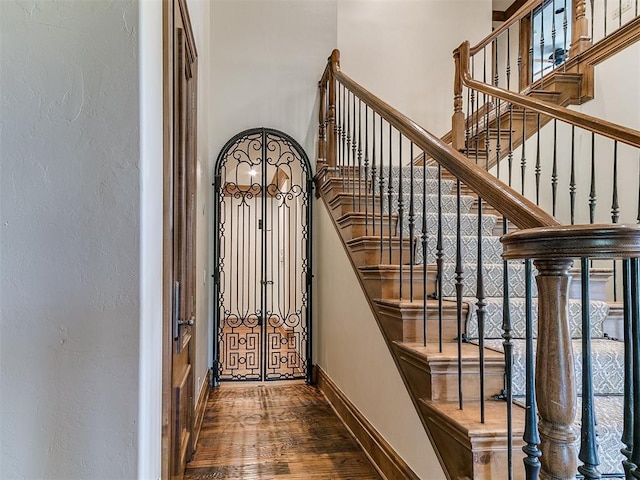 5708 Normandy Ter, Oklahoma City, OK 73142 - stairway featuring a towering ceiling, wood finished floors, and a textured wall