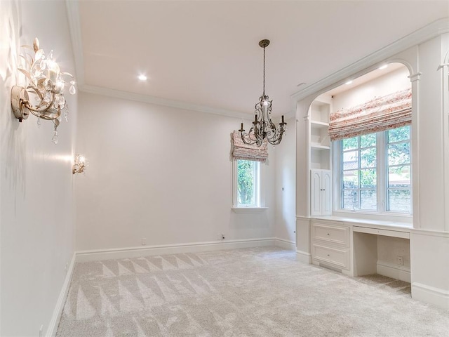 5708 Normandy Ter, Oklahoma City, OK 73142 - empty room featuring built in study area, light colored carpet, crown molding, a chandelier, and arched walkways