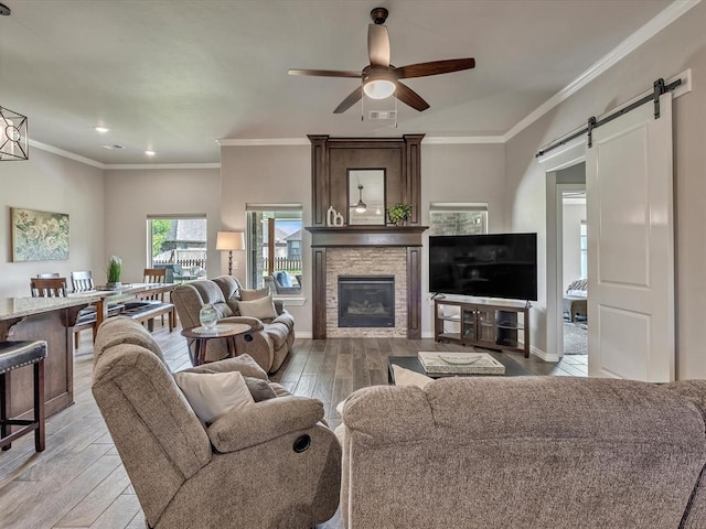 18716 Lazy Grove Dr, Edmond, OK 73012 - living area featuring ceiling fan, a barn door, light wood finished floors, recessed lighting, and a stone fireplace
