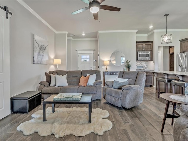 18716 Lazy Grove Dr, Edmond, OK 73012 - living area featuring ceiling fan, recessed lighting, wood finished floors, ornamental molding, and a barn door