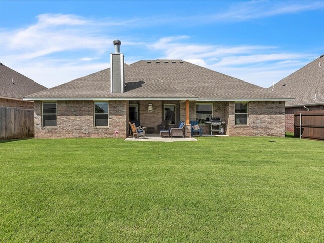 18716 Lazy Grove Dr, Edmond, OK 73012 - rear view of property featuring a chimney, a fenced backyard, roof with shingles, a patio area, and brick siding