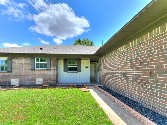 502 Walnut Ave, Yukon, OK 73099 - property entrance with brick siding, a yard, and a shingled roof