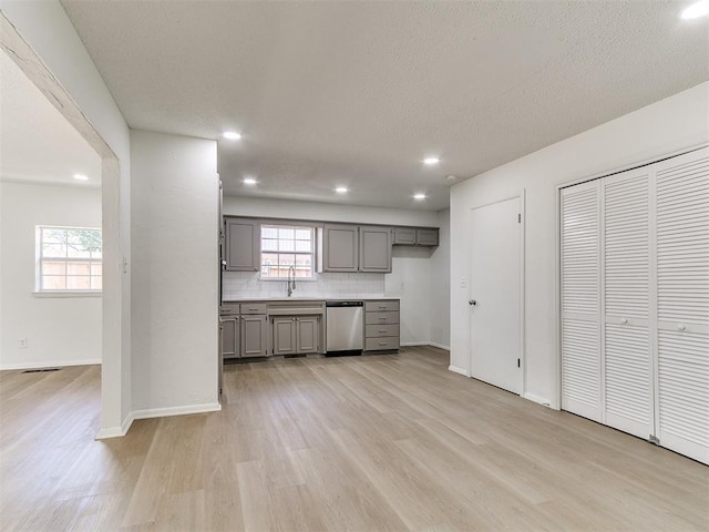 502 Walnut Ave, Yukon, OK 73099 - kitchen with gray cabinets, stainless steel dishwasher, light wood-style flooring, backsplash, and recessed lighting