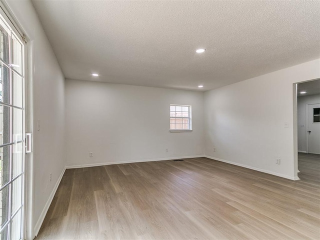502 Walnut Ave, Yukon, OK 73099 - unfurnished room featuring light wood-style flooring, a textured ceiling, and recessed lighting