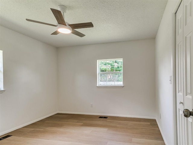 502 Walnut Ave, Yukon, OK 73099 - empty room featuring light wood-style floors, a textured ceiling, and a ceiling fan