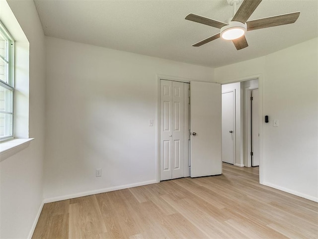 502 Walnut Ave, Yukon, OK 73099 - unfurnished bedroom with light wood-style flooring, multiple windows, a closet, and a ceiling fan