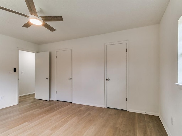 502 Walnut Ave, Yukon, OK 73099 - unfurnished bedroom with wood finished floors, a ceiling fan, and two closets